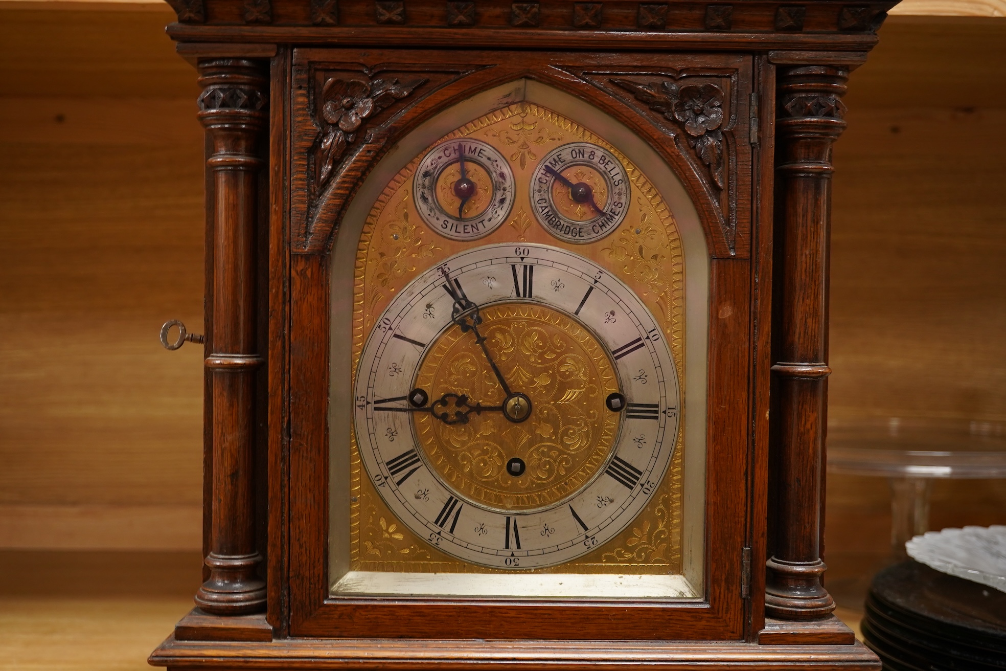 A German Gothic style oak mantel clock, early 20th century, with pendulum and keys, 49cm high